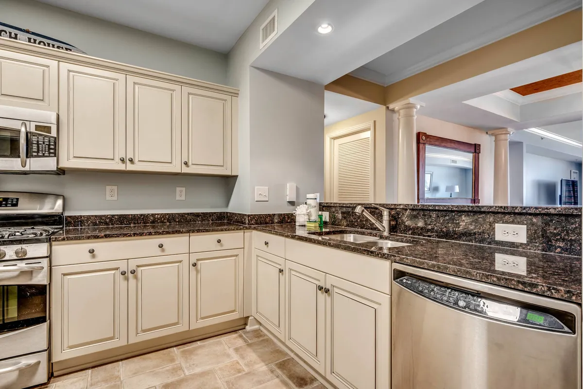 A modern kitchen with gleaming granite countertops and stainless steel appliances is shown, offering ample space for cooking and entertaining. The cabinetry and layout suggest a fully equipped and functional kitchen ideal for preparing gourmet breakfasts or casual snacks.