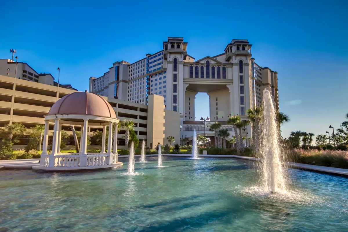 An ornate gazebo and water fountains are set before the architectural features of the resort, creating a serene outdoor gathering space ideal for winding down after an active day. The calm setting encourages socializing and relaxation.