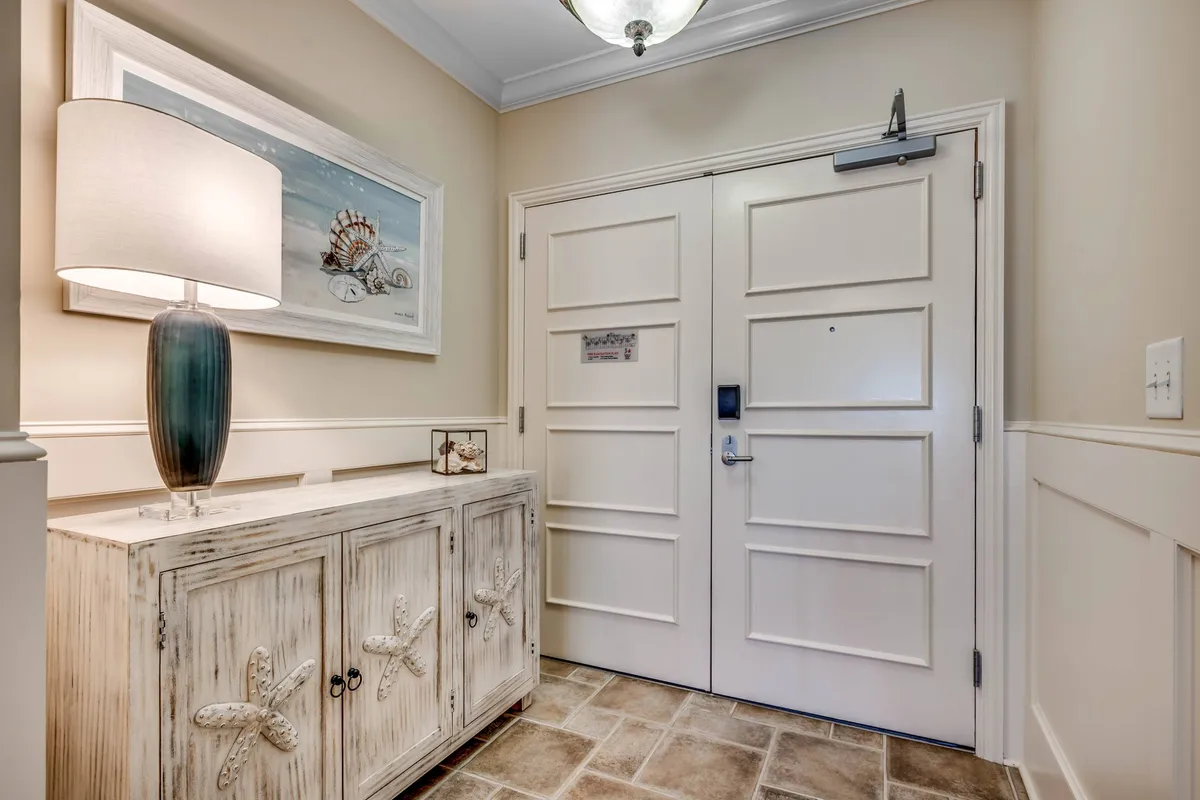 This interior shot highlights the condo’s welcoming entryway, complete with a stylish console table, decorative lamp, and inviting wall art by the front door. The scene captures the inviting mood and hints at the anticipation of guests arriving for a getaway.