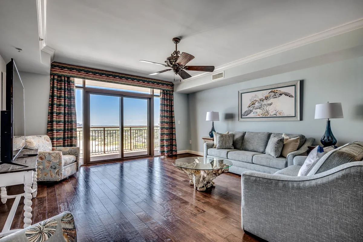 This image showcases a living space with large windows revealing a sweeping ocean view. The plush seating is arranged to foster conversation and relaxation, while decorative art adds a touch of personality. The abundance of natural light and seamless indoor-outdoor connection highlight the tranquil and inviting mood of the space.